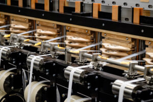 Machines weaving together textiles.
