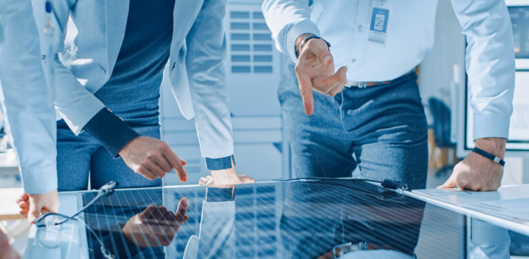 Team Meeting of Renewable Energy Engineers Working on an Innovative More Efficient Solar Panel Battery Concept. Group of Specialists Gathered Around Table, Solving Problems